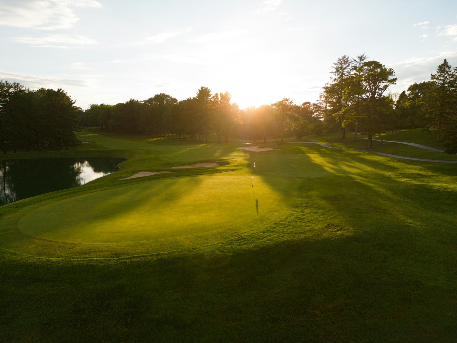 Last light raking across an empty green at the end of the day.